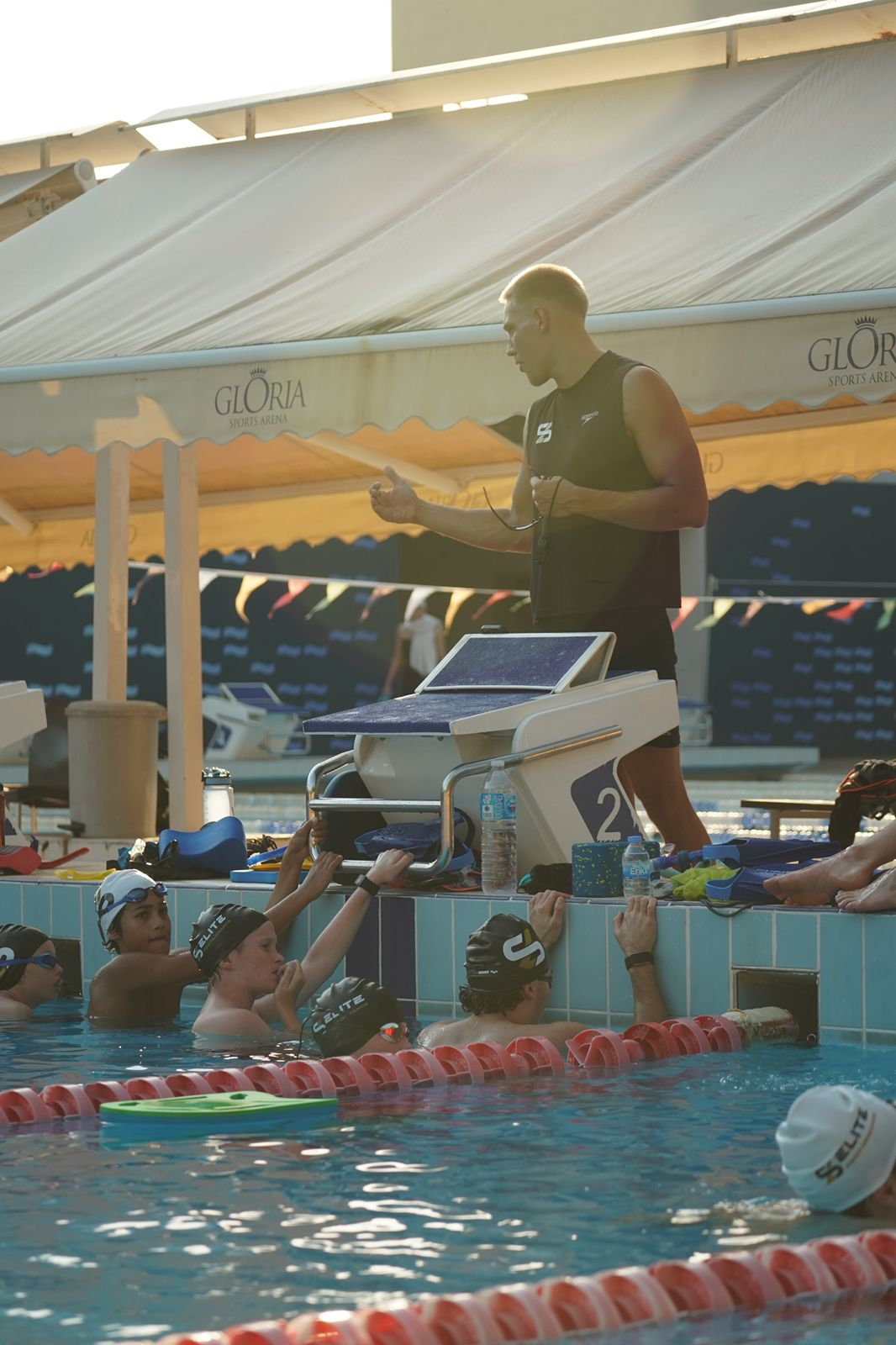 Leo briefing swimmers at the wall between sets